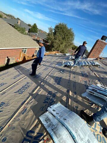 Crew members working hard to place the shingles on the Roof.