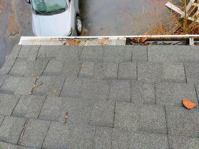 Clogged gutters with the remains of old gutter guards