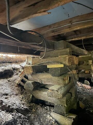 Before: Improvised Foundation of Stacked Logs
