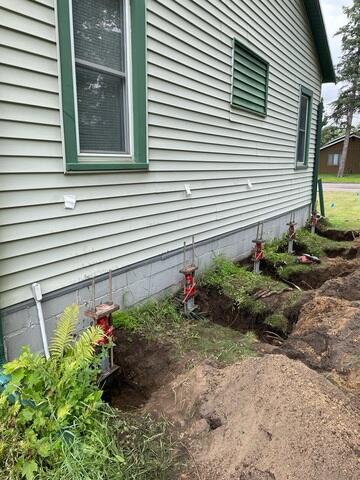 Helical Piers Installed Along Home Exterior