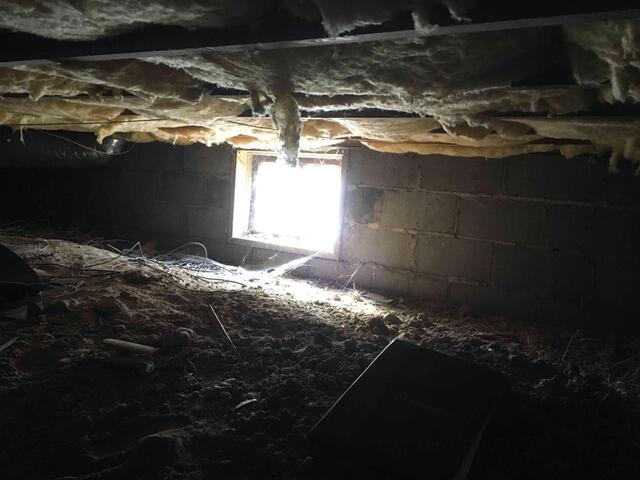 Crawl Space with Exposed Soil and Debris