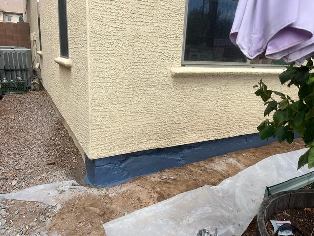 Exposed stem wall with corrosion‑inhibiting blue barrier in Queen Creek, AZ