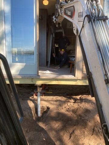 Installing Helical Piers Beneath Cabin Foundation
