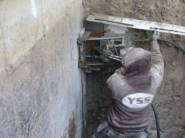 The 24" blade is able to cut to a depth of 9". Larger blades can be used for deeper depths of cut. The saw uses water to both cool the blade and make dust a non-issue. The cut was continued to the top of the abandoned wall and the active foundation was free to be lifted.