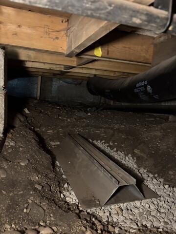 A large aluminum plate is set in gravel and will act as a footing for the Smartjack