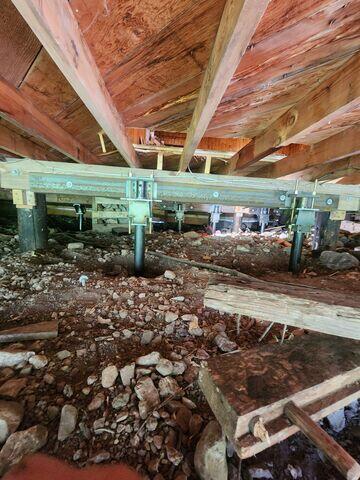Multiple SmartJack supports and a supplemental steel beam were installed beneath the home's crawl space to stabilize weakened floor framing and help restore structural integrity in Salt Lake City, Utah.