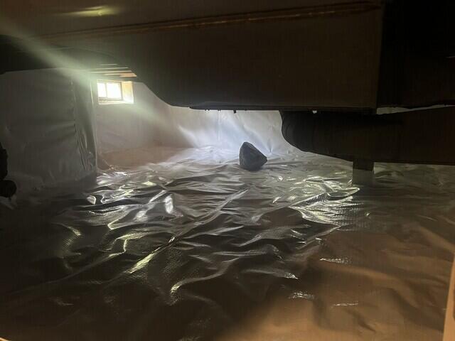 Cross laminated vapor barrier sealed over crawl space floor and wall