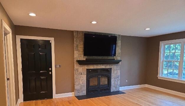 Updated wall colors, refinished trim, and a black accent door that perfectly complement the natural stone fireplace.