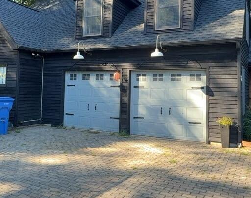 Complete exterior home transformation featuring immaculate black siding and refreshed garage accents.