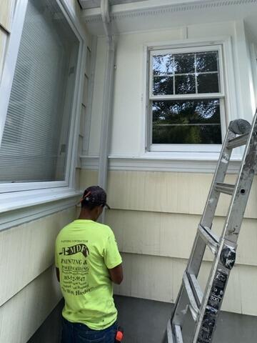 Our professional painting contractor carefully repairing and painting exterior siding and trim sections.
