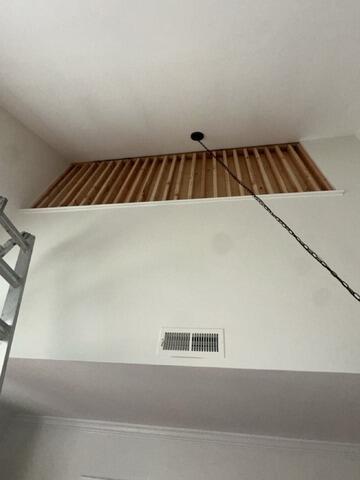 Custom wood stud framing installed inside a high ceiling wall opening for structural support.