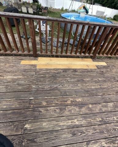 Replacing damaged floorboards with high-quality, pressure-treated lumber for seamless deck repairs.