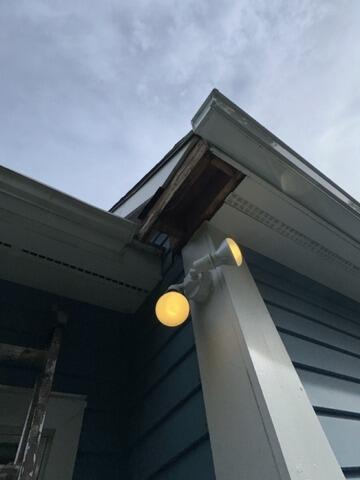 Identifying rotted eave section and exposed soffit structure prior to repair.