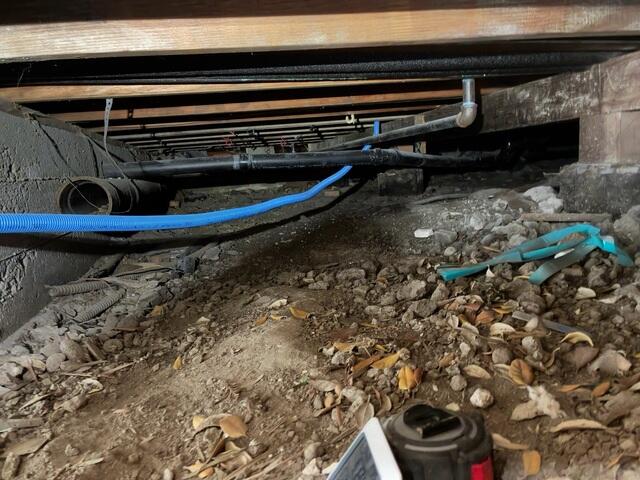 Debris Beneath the Home Before Crawl Space Cleanup