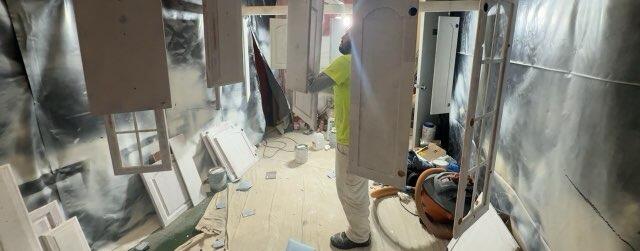 Skilled technicians inspect every cabinet door in a fully contained spray area to ensure complete coating coverage and a smooth finish.