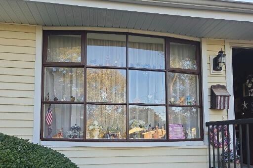 After: Restored and repainted bay window trim paired with clean, brightened vinyl siding.