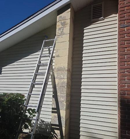 Before: Preparing the ladder for high-reach surface prep, scraping, and priming on a worn exterior chimney
