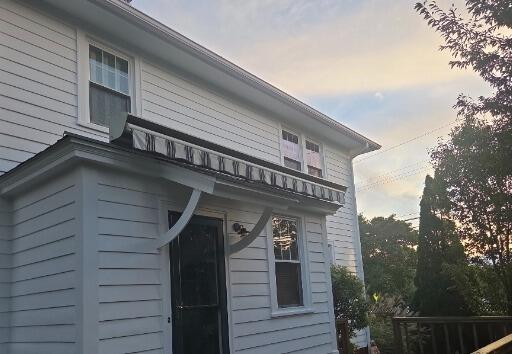 Freshly painted smooth white siding and pristine trim work around the back entrance and deck area.