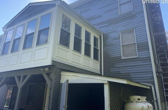 Meticulous scraping and spot priming worn cedar siding to ensure maximum paint adhesion and protection.