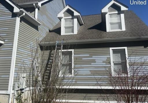 Detailed surface prep and primer patch-work around front dormer windows and accent trim.