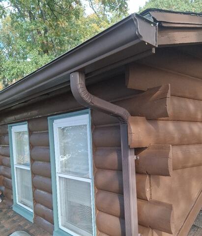 Freshly primed and painted dormer trim detailing completed along upper roofline sections.