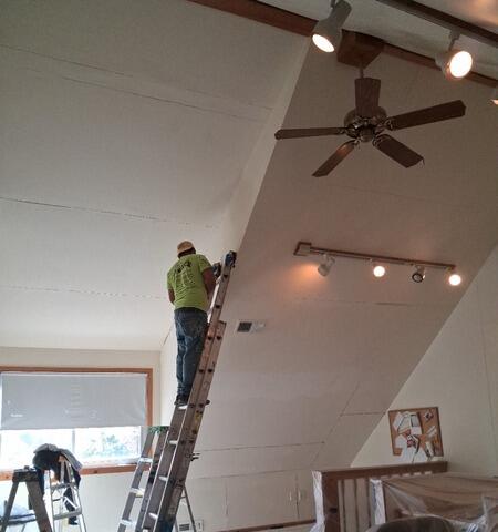 Safe extension ladder setup and expert drywall repair for high, sloped ceiling painting projects