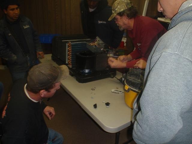 Several of the crew getting into the guts of the machine