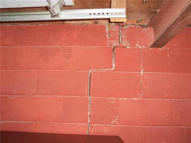 While in poured walls you may see diagonal cracks from doorframes when something is amiss with the foundation, block walls present problems in the form of a stairstep crack like the one seen here.