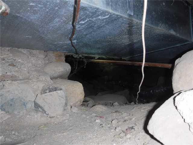 Unprotected Crawl Space Susceptible to Debris and Moisture