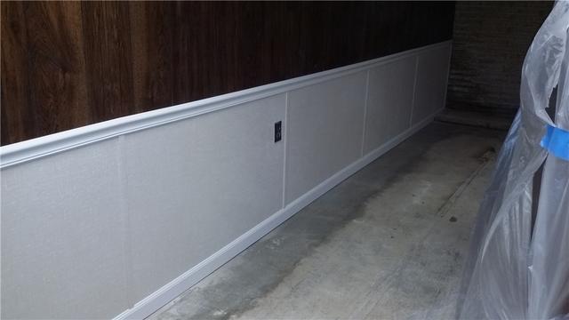 By incorporating the existing outlet and installing trim and baseboard, we don't lose any of the finished wall look. This wall just won't warp and mold.