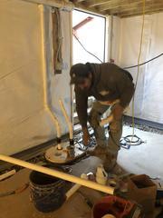One of our crew members installing our sump pump system