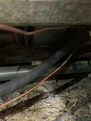 wiring and tubes that liter the crawl space