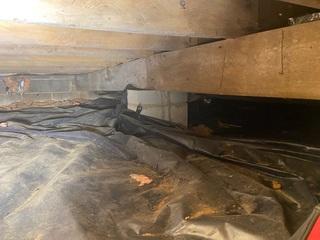 This photo shows the crawlspace before we started work. You can see in this picture the beam that goes through out the home is not straight. This beam is slanted causing the floors above to sagg.