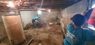 After installing our waterproofing system our team started to remove the concrete that they had to jackhammer in order to create our trenches. In order to get it out of the basement they had to pass it through a small window in the basement to a team of two one the outside.