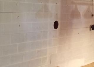 This is what the wall in this homeowners basement looked  like. You can see the vertical crack running all the way across the middle of the wall as well as a second crack starting to form above it.