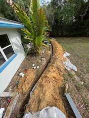 LRE digs trenches all around this home before laying the right amount of pipe down. This pipe ultimately will divert the flow of water out into the yard.