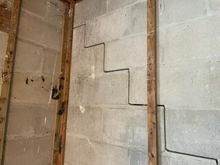 Upon removing the drywall from the rear of the home, the contractor uncovered significant stair-step cracks, indicating a serious case of foundation settlement.