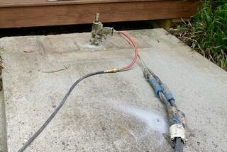 Small holes are drilled into the concrete, this tool inserts poly foam into the hole which lifts the concrete and quickly hardens.