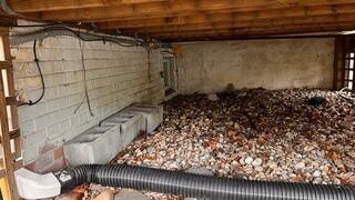 This is a before photo of under the deck. If you look closely you can see the settlement in the foundation and some stair step cracking in the brick.