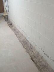 A trench is created around the basement perimeter for installation of the WaterGuard drainage system.