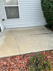 Soil settlement has caused the concrete slab of the homeowner's back patio to both crack and settle, creating not just an unpleasant appearance but also a potential tripping hazard.