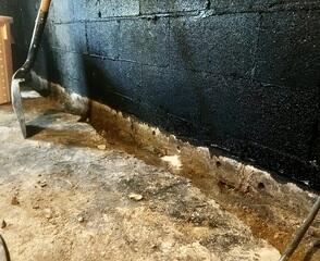 A trench is carefully jack hammered around the edge of the basement.