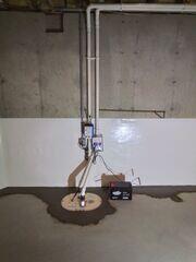 This TripleSafe sump pump has three layers of protection against basement moisture. The black battery (to the right of the TripleSafe cover) acts as a backup in the event of a power outage.