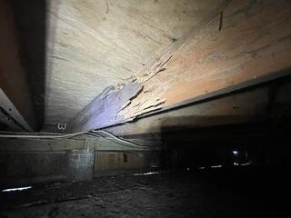 Severe termite damage to the wooden floor joists in the crawl space compromised their ability to provide adequate support.