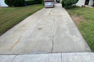Soil erosion and the weight of heavy equipment had caused the homeowner's concrete driveway to sustain heavy damage throughout the surface.