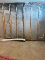 Concrete is porous, meaning it allows moisture to pass through it. For basements with high water tables, it is wise to install some type of moisture barrier system before finishing with drywall.