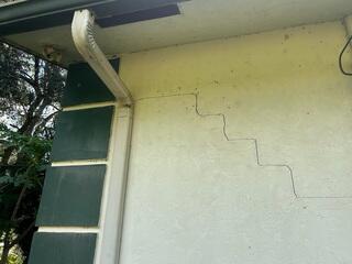 The appearance of stair-step cracks along the exterior walls signaled to the homeowner that the foundation beneath the garage had settled.