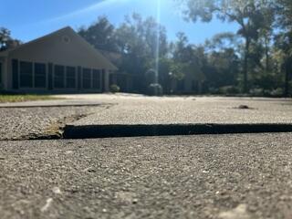 Sections of the homeowner's concrete driveway had settled and become uneven, creating notable tripping hazards.