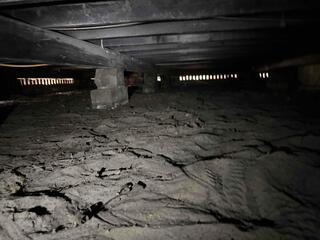 Upon inspecting the crawl space, the LRE Design Specialist observed that many of the block piers supporting the wooden support joists above had settled into the soil below.