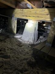 An inspection by an LRE Design Specialist revealed that the block piers in the crawl space, which supported the home's wooden floor joists, had settled into the underlying soil, leaving the floor joists without stable support.